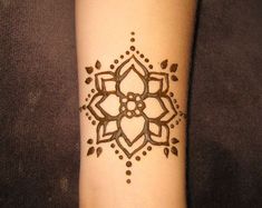 a woman's arm with a henna tattoo on it