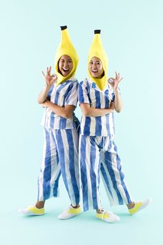 two people dressed in blue and white striped pajamas with bananas on their heads, standing next to each other