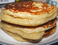 three pancakes stacked on top of each other on a white plate with blue and white stripes