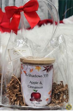 an apple and cinnamon gift basket with a red bow