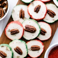 apples and pecans are arranged on a cutting board