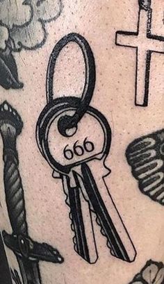 a close up of a person's leg with tattoos on it and keys in the middle