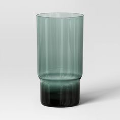 a green glass sitting on top of a white table