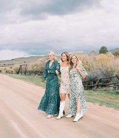 three women are walking down the road together