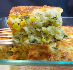 a close up of a piece of food on a fork with broccoli and corn casserole