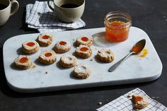 some cookies are on a tray with jam