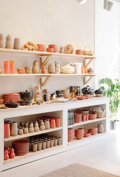 the shelves are filled with different types of pottery