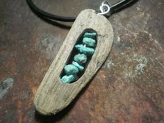 a wooden necklace with turquoise stones in it