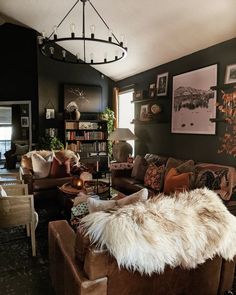 a living room filled with lots of furniture next to a book shelf full of books