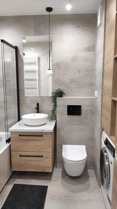 a white toilet sitting next to a sink in a bathroom