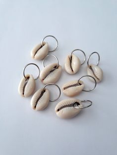 Set of 8 loc rings made with off white natural cowrie shells on stainless steel rings.  Rings fit all locs and braids. Cowrie Shell Hair Accessories, Cowries On Hair, Cowrie Shells On Locs, Shells On Locs, Braid Jewelry Hair Accessories, Loc Rings, Loc Ideas, Braid Rings, Dreadlock Jewelry