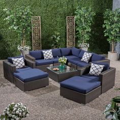 an outdoor living room with blue cushions and greenery