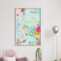 a living room with a pink chair and a framed poster on the wall above it