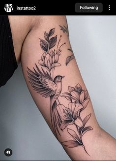 a bird and flowers tattoo on the arm