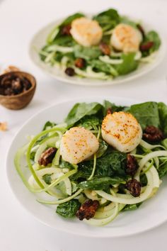 a white plate topped with salad and scallops