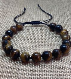 Tiger's eye knotted bracelet that is adjustable.   Tigers Eye is good for growing your confidence and strength and it is known as the stone of courage. It is a root and sacral chakra stone which means it helps you to get grounded, build a safe and strong foundation, and find your motivation once more. It's also good at warding off negative energy. Multi stone bracelet contains healing stones jade and agate. Adjustable Braided Bracelets With 8mm Beads For Healing, Adjustable Brown Crystal Bracelet With 8mm Beads, Adjustable Hand-strung Brown Crystal Bracelet, Adjustable Brown Hand-strung Crystal Bracelet, Sacral Chakra Stones, Chakra Racine, Bracelet Knots, Sacral Chakra, Tiger Eye Beads