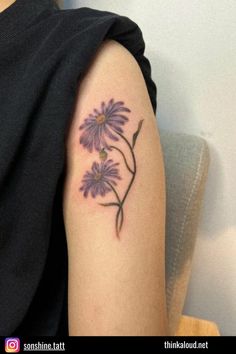 a woman's arm with a purple flower tattoo on the left side of her arm