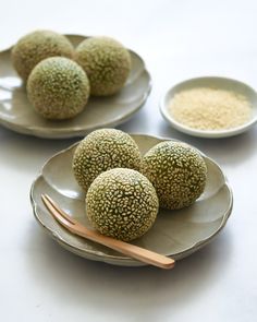 three plates with different types of food on them, one has sesame seeds and the other has broccoli sprouts