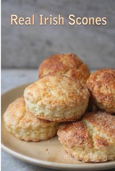 four biscuits on a plate with the words real irish scones