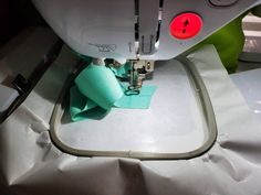 the sewing machine is sitting on top of the table next to the green piece of cloth