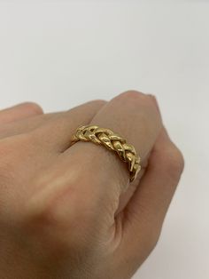 a person's hand with a gold ring on it