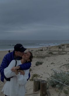 a man and woman kissing on the beach