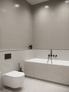 a white bath tub sitting next to a toilet in a bathroom