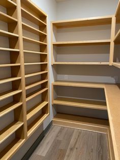 an empty walk in closet with wooden shelves