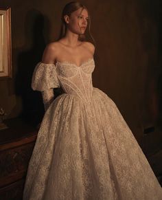 a woman in a white dress standing next to a mirror with her hands on her hips