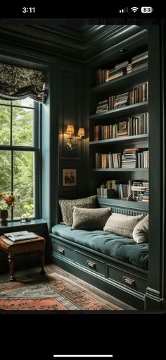 a living room with bookshelves and couches in front of a large window