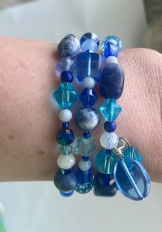 This bracelet features beads in many shades of blue: * Tumbled nugget and 8 mm round sodalite beads * 4 mm round blue lace agate beads * Czech crystal beads * Glass beads  The bracelet is strung on memory wire and wraps three times around your wrist I design and make beaded necklaces and bracelets. Every item is unique and one of a kind! Blue Spiritual Wrap Bracelet With Gemstone Beads, Spiritual Blue Gemstone Beads Wrap Bracelet, Spiritual Blue Wrap Bracelet With Gemstone Beads, Blue Wrap Bracelet With Natural Stones For Healing, Blue Gemstone Beads Wrap Bracelet, Blue Gemstone Beads Wrap Bracelet With Round Beads, Blue Lapis Lazuli Bracelets With Natural Stones, Blue Bohemian Crystal Bracelet With Round Beads, Adjustable Blue Lapis Lazuli Bracelets