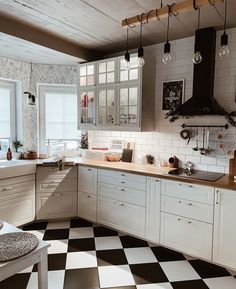 a black and white checkered floor in a kitchen with lots of counter top space