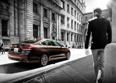 a man walking down the street next to a car