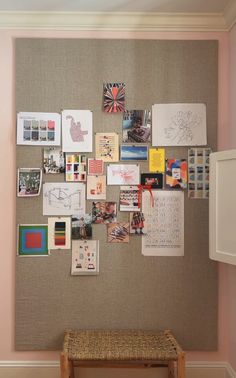 a bulletin board with many pictures on it and a wooden bench in front of it