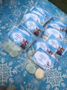 frozen princess themed baby shower favors on a table with snowflakes and frosting