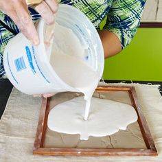 a person pouring milk into a pan on top of a table