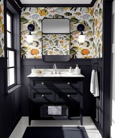 a black and white bathroom with floral wallpaper on the walls, two sinks and a large mirror