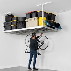 a man holding a bike on top of a white shelving unit with bins