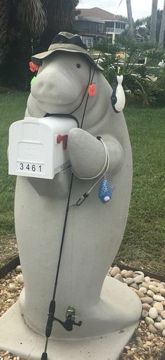 a statue of a polar bear is holding a box with an ice cream machine on it