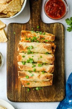 mexican food on a cutting board with salsa and tortillas