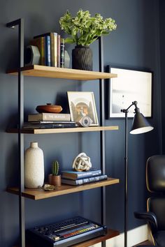 a bookshelf with three shelves and a lamp in the corner next to it