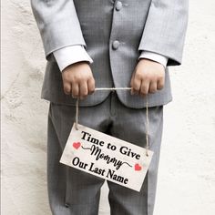 a man in a suit holding a sign that says time to give mommy our last name