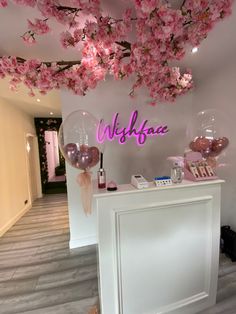 the reception area is decorated with pink flowers and balloons