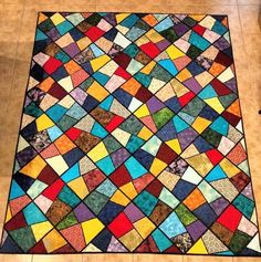 a multicolored patchwork rug on the floor in a room with tile floors