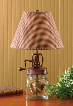 a lamp that is sitting on top of a table next to a book and some flowers