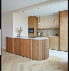 a large kitchen with wooden cabinets and white counter tops, along with wood flooring