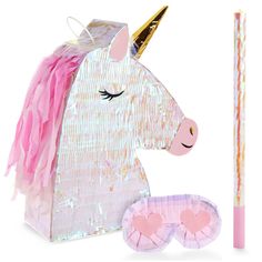 a pink and gold unicorn mask next to a pair of eyeglasses on a white background