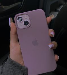 a woman holding an iphone case in her hand while sitting in the driver's seat