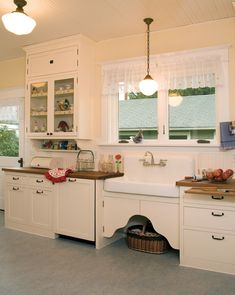 a large kitchen with white cabinets and counter tops in an open floor plan that is well lit