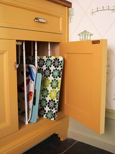 an open cabinet with some items in it on the bottom shelf and another item inside